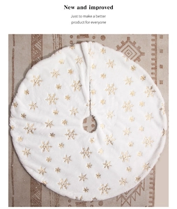 Detail of white plush Christmas tree skirt with embroidered gold snowflake sequins