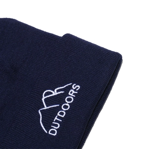 Detailed close-up of navy knit beanie featuring white mountain embroidery and Outdoors text