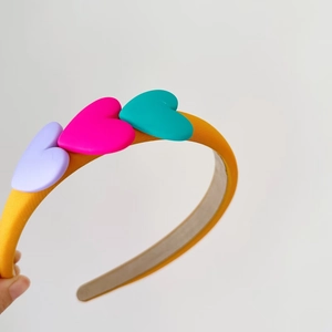 Detail of sweet sponge headband with colorful 3D heart charms in purple, pink and green