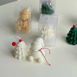 Detailed macro view of handmade mini Christmas tree and bear shaped decorative wax candles
