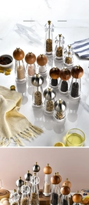 Detail view of manual pepper grinders with wood lids and transparent acrylic bodies