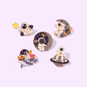 5-piece set of astronaut enamel pins with creative space designs on a soft purple background