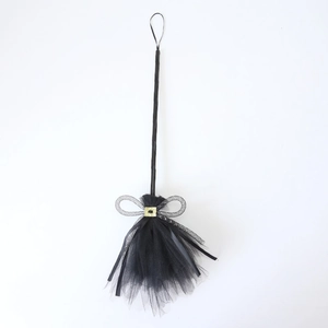 Detail of black mesh Halloween witch broom with gold buckle and sequins on white background