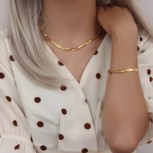 Elegant gold titanium steel herringbone necklace and bracelet set for women on model
