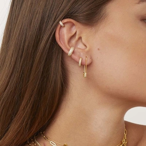 Gold plated safety pin earring set with zircon stones on female model ear