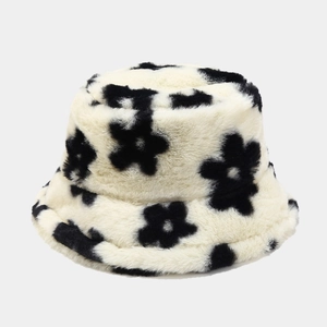 Detail of soft faux fur bucket hat featuring a vintage black floral pattern on white plush