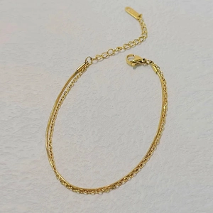Detail of 18k gold double-layer snake and link chain bracelet with lobster clasp