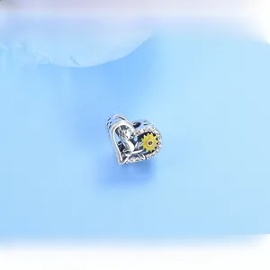 Macro shot of silver heart charm with cat and yellow sunflower detailing and zircon inlay