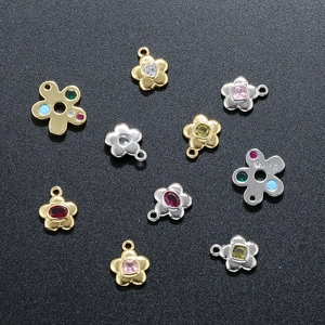 Detailed view of floral copper pendants with colorful crystals in gold and silver plating
