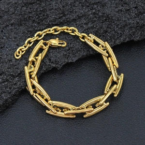 Detailed macro shot of a chunky gold industrial chain bracelet on dark stone texture