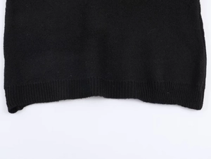 Detailopname van de zwarte gebreide geribbelde zoom met zachte en luxe textuur