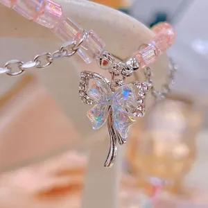 Silver bow pendant with iridescent center and pink crystal beads on a delicate necklace