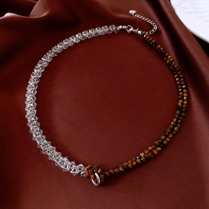 Détail du collier en perles d'œil de tigre et cristal avec breloque cœur et fermoir argent