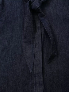 Détail du nœud papillon sur un tissu en denim bleu foncé avec une texture nette