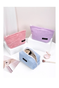 Macro view of textured corduroy makeup bags with velvet feel and metal zipper detail