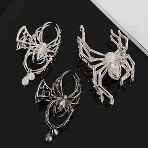 Silver and dark gray spider hair claws with pearls and crystals on black background