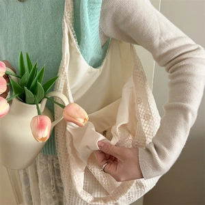 Detail of creamy white lace tote bag featuring fabric lining and secure zipper pocket