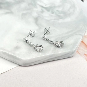 Close-up of elegant S925 silver drop earrings with sparkling clear zircon pendants