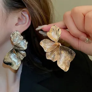 Exaggerated metal flower earrings with wrinkled texture in gold and silver finish