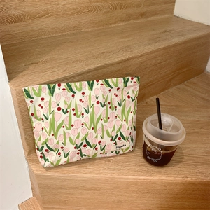 Detail of canvas tulip pouch with Sozakka label on wooden stairs beside coffee