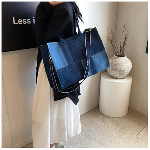 Detail of multi-tone denim patchwork tote bag with adjustable canvas shoulder strap