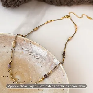 Close-up of beaded necklace with 40cm chain and lobster clasp on ceramic plate