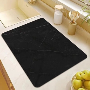 Rectangle black marble absorbent kitchen mat placed on countertop near a modern sink