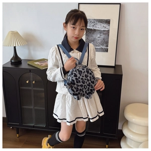 Detailed plush texture and leopard print pattern on kids backpack in home setting