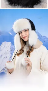 Close-up of white plush trapper hat with faux fox fur and soft earmuffs for winter