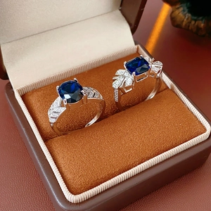 Détail de deux bagues en argent avec zircons bleus dans un écrin à bijoux