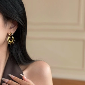Star-patterned tiger eye gold earrings on model with high-end vintage aesthetic