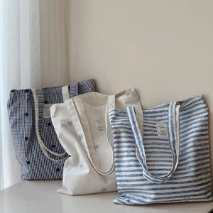 Detailed embroidery and striped patterns on three cotton canvas tote bags