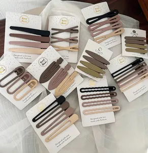 Detailed view of matte brown hair clip set in various shapes on white card packaging