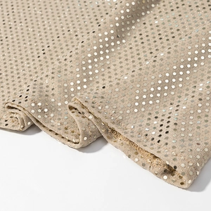 Gros plan de sequins scintillants sur tissu champagne avec texture de robe de soirée
