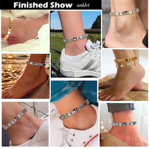 Modulaire Italiaanse schakelarmband met goud en zilveren bedels om de enkel