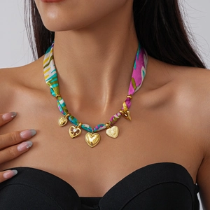 Detail of a fabric floral choker necklace with golden heart pendants and bohemian patterns