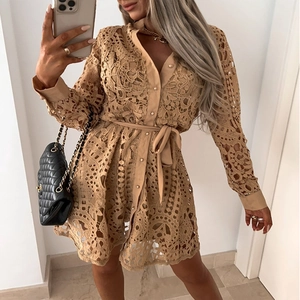 Détails de la robe en dentelle ajourée beige avec boutonnage et taille nouée