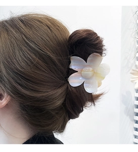 Close-up of a floral acetate hair claw clip with yellow and white gradient petals