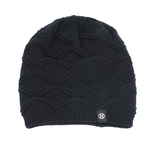 Close-up of black diamond knit pattern and H-logo label on thick thermal winter beanie