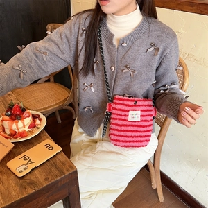 Détail du sac à bandoulière en peluche à rayures roses et rouges avec texture douce