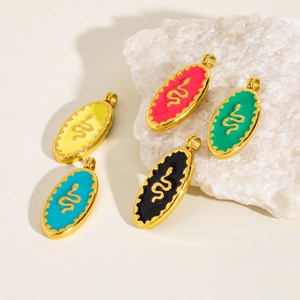 Colorful enamel snake pendants in gold finish on a textured white stone background