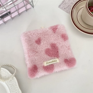 Close-up of pink plush square coaster with heart pattern and Sozakka brand tag