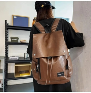 Dettaglio zaino vintage in pelle marrone con chiusura a coulisse e tasche laterali