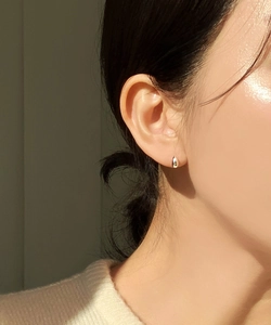 Nahaufnahme von minimalistischem Silber-Wassertropfen-Ohrring mit poliertem Finish