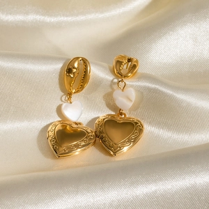 Golden heart locket drop earrings with white shell and shell-shaped stud on silk fabric