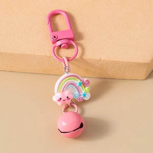Detailed shot of pink Christmas keychain with rainbow charm, metal bell, and spring hook