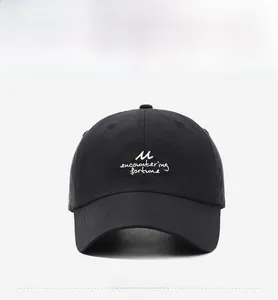 Detail shot of black quick-dry cap featuring white M and fortune letter embroidery