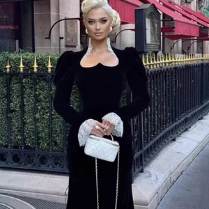 Elegante abito in velluto nero con pizzo bianco e vita stretta mostrato in un look urbano
