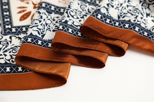Macro shot of two-tone paisley silk scarf showing vintage pattern and smooth texture