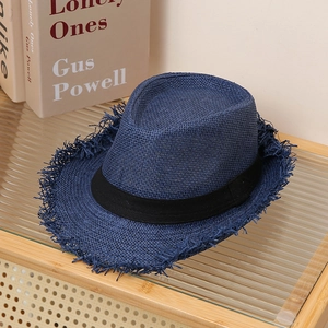 Detailed view of dark blue straw fedora with raw edges and a classic black ribbon band